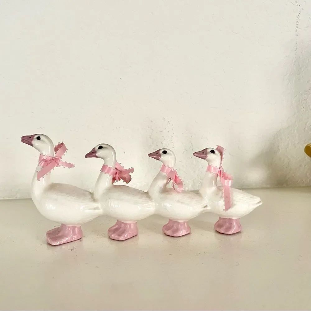 4 White ceramic ducks with pink and bows